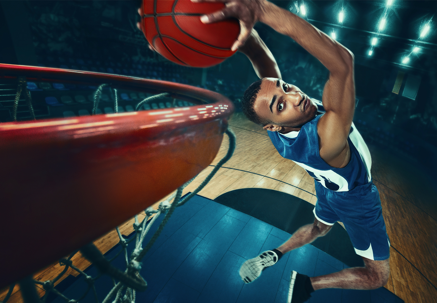 An African male basketball player jumping with ball